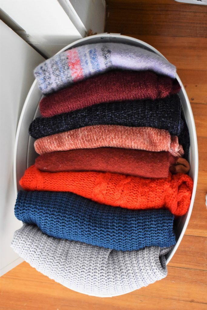 sweaters folded in bucket
