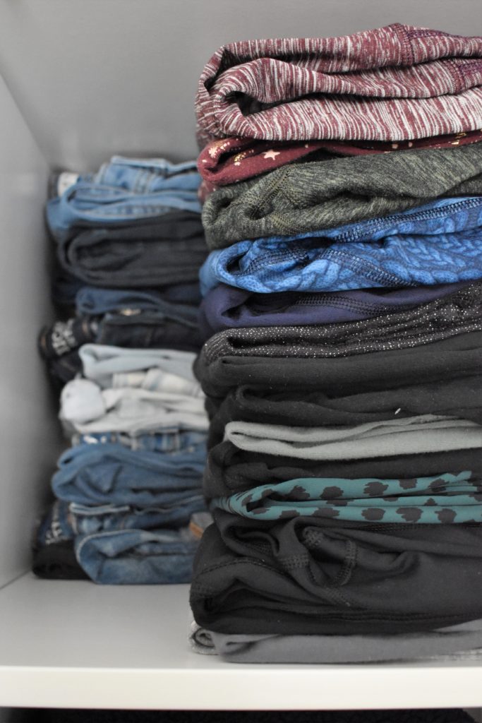 Jeans and leggings folded on shelf